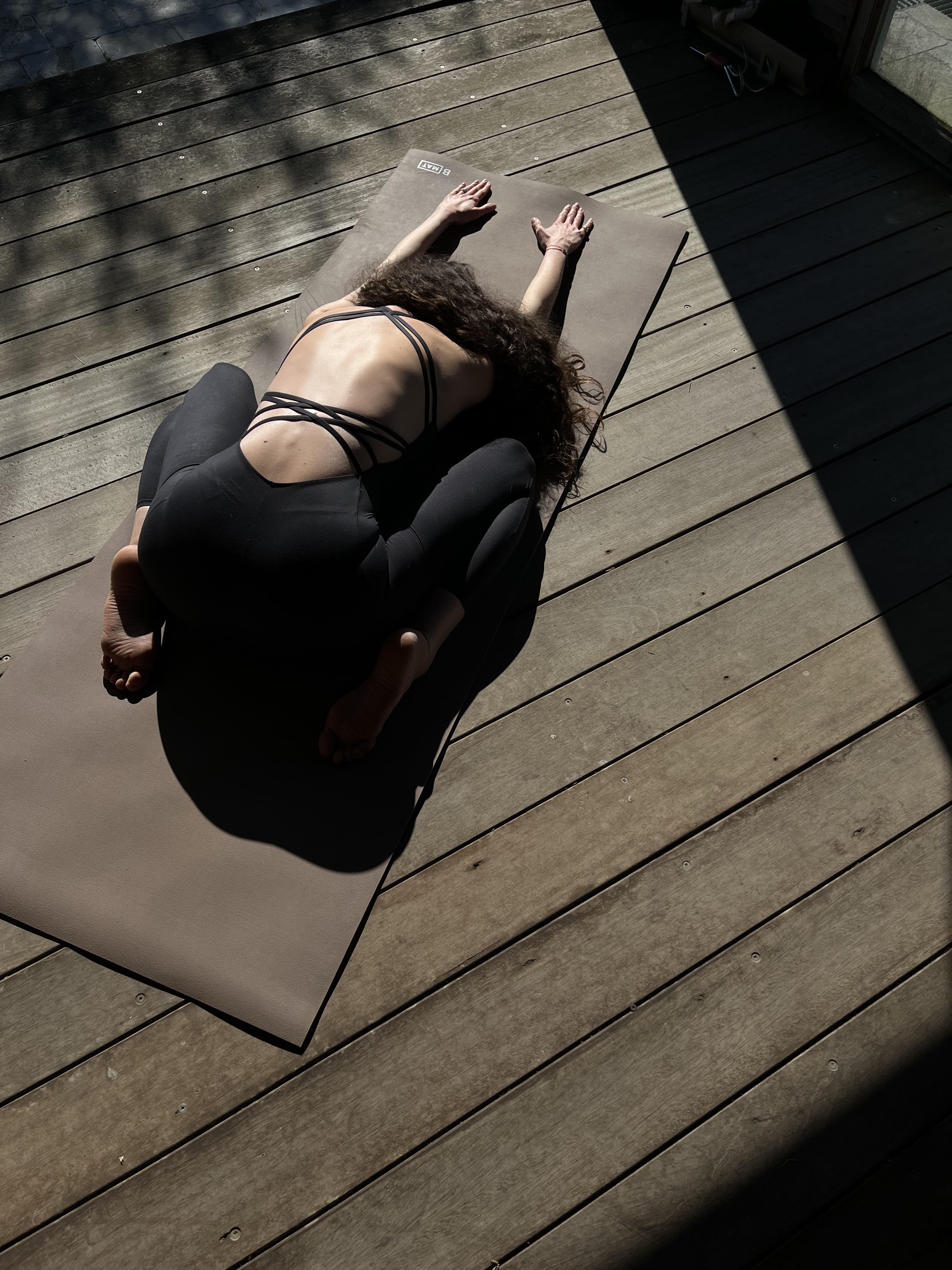 Person practicing yoga on wooden deck